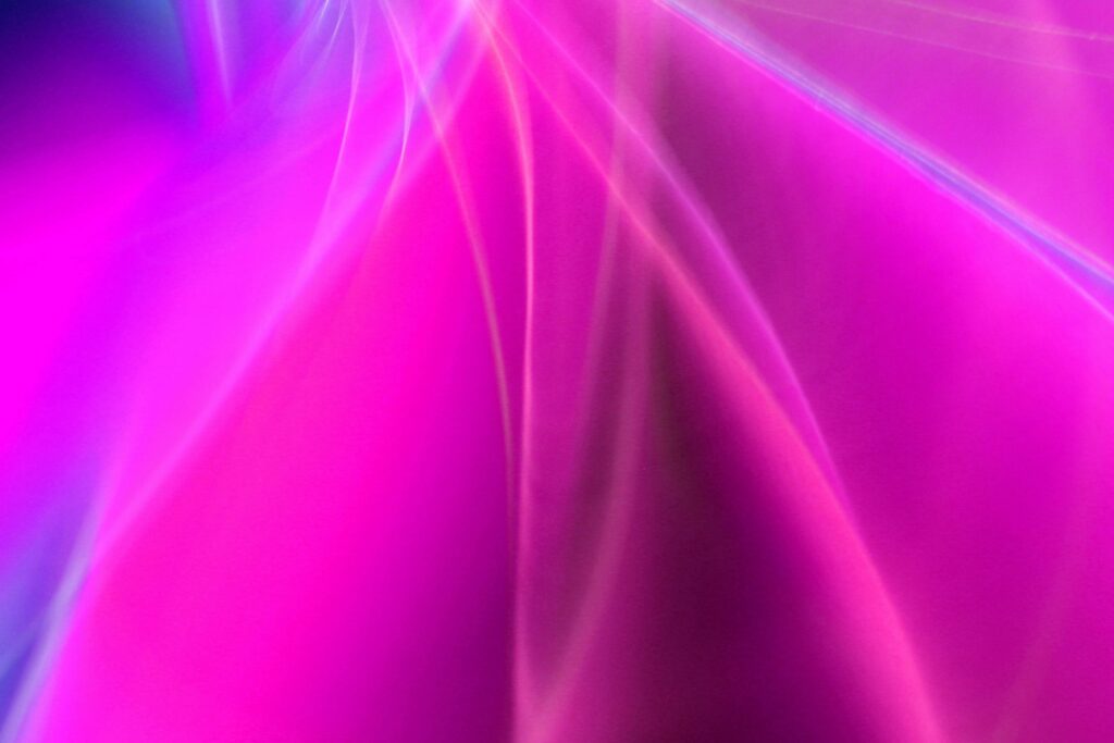 Dynamic and vivid abstract neon light streaks in pink and purple hues.